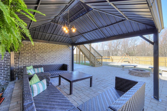 view of patio with an outdoor living space with a fire pit, a gazebo, stairway, and fence