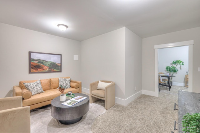 carpeted living room with baseboards