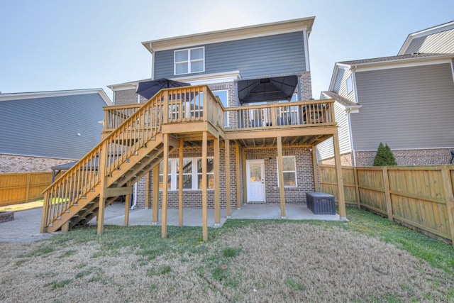 back of property with a fenced backyard, stairs, a lawn, a patio area, and brick siding