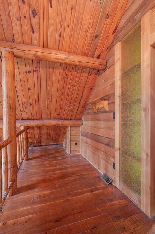 bonus room featuring hardwood / wood-style floors, wooden walls, visible vents, a sauna, and wooden ceiling