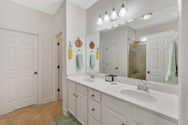 full bath featuring a sink, a shower with shower door, double vanity, and tile patterned floors