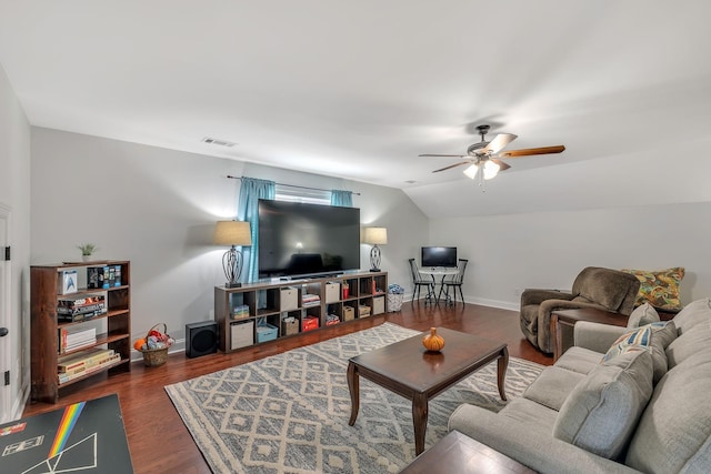 living area featuring visible vents, baseboards, lofted ceiling, and wood finished floors