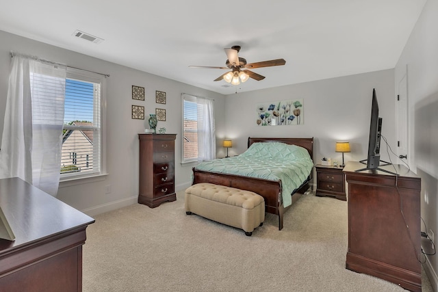 bedroom with visible vents, baseboards, light colored carpet, and ceiling fan