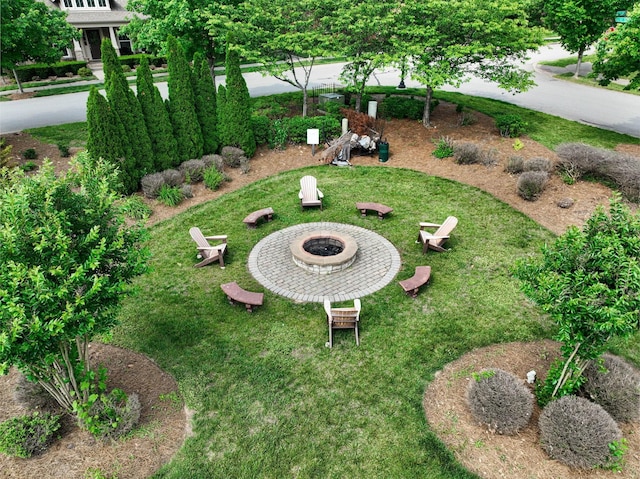 view of yard featuring concrete driveway and an outdoor fire pit