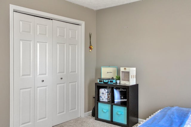 bedroom with a closet, carpet flooring, and baseboards