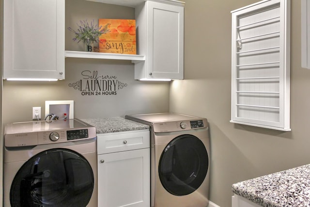 washroom with cabinet space and washer and clothes dryer