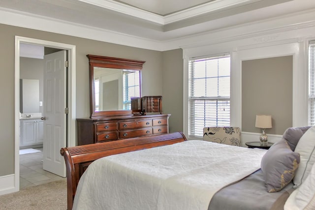 bedroom featuring light tile patterned floors, crown molding, ensuite bathroom, light carpet, and a raised ceiling