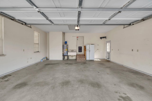 garage featuring gas water heater, white refrigerator with ice dispenser, and a garage door opener