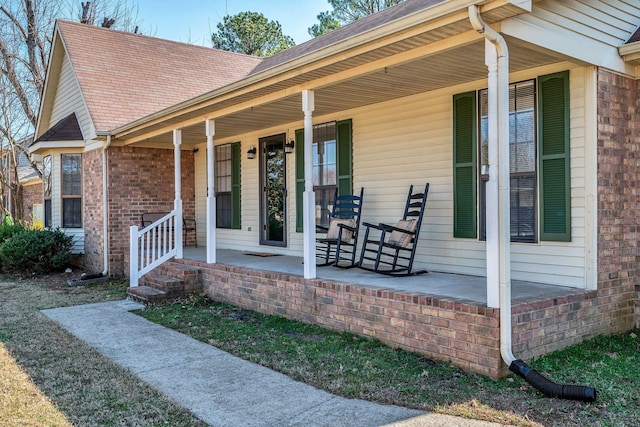 property entrance with brick siding and covered porch