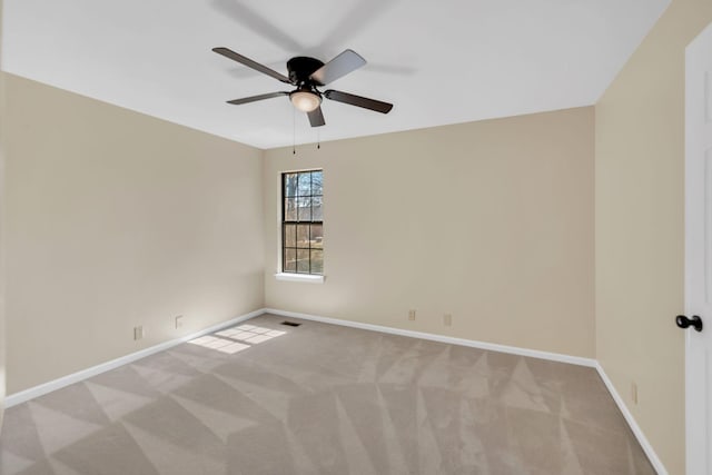 empty room with visible vents, baseboards, carpet floors, and ceiling fan