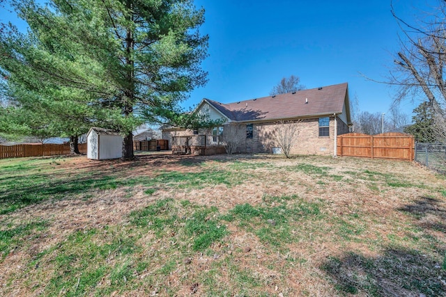 exterior space with crawl space, a storage shed, a fenced backyard, and brick siding