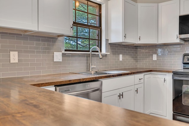 kitchen featuring decorative backsplash, white cabinets, appliances with stainless steel finishes, and a sink