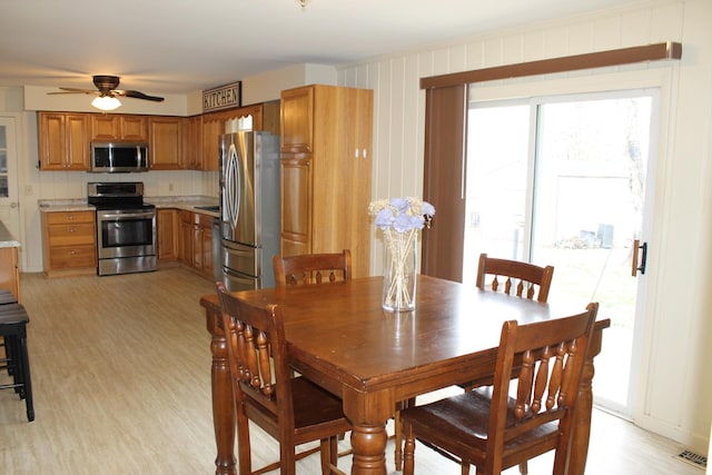 dining space featuring visible vents, light wood-style flooring, and a ceiling fan