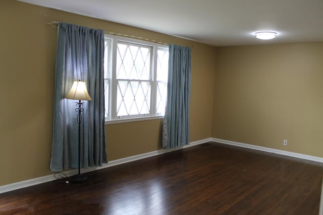 unfurnished room with baseboards and wood finished floors