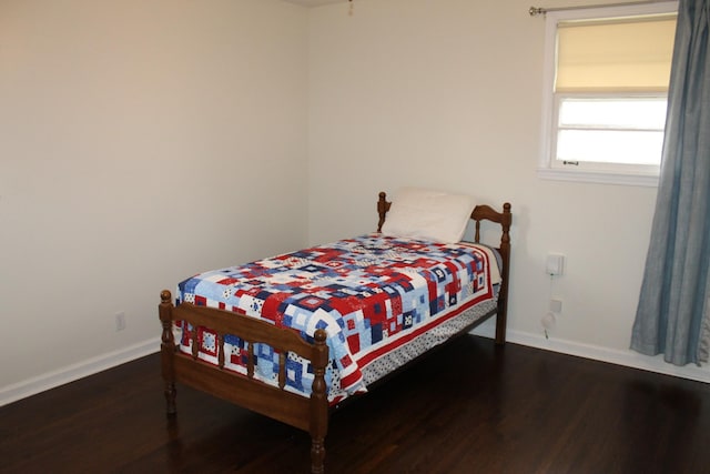 bedroom with baseboards and wood finished floors