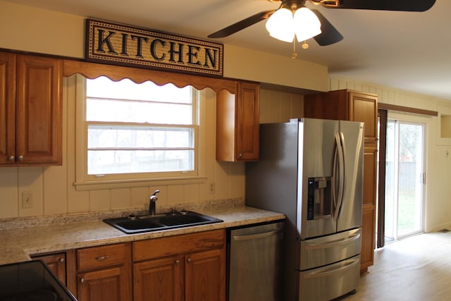 kitchen featuring a sink, stainless steel appliances, and brown cabinets