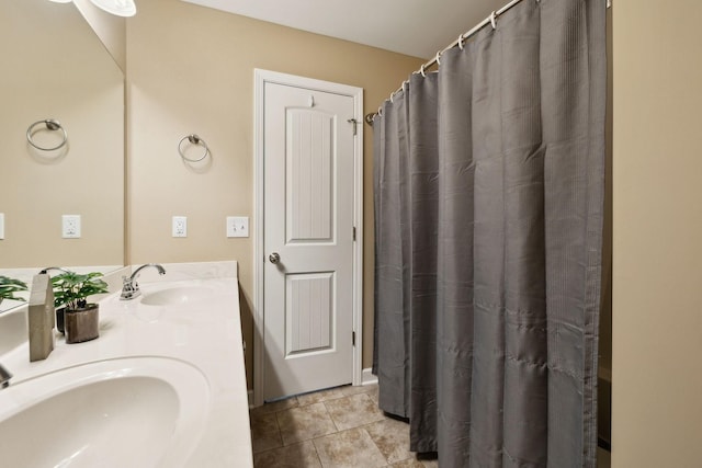 bathroom with tile patterned floors, double vanity, and a sink