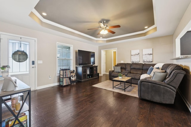 living area with ceiling fan, a raised ceiling, baseboards, and hardwood / wood-style flooring