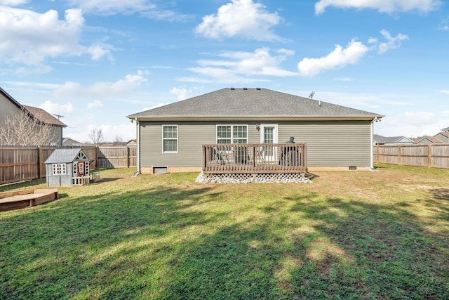 back of property with a deck, a lawn, a fenced backyard, and a garden