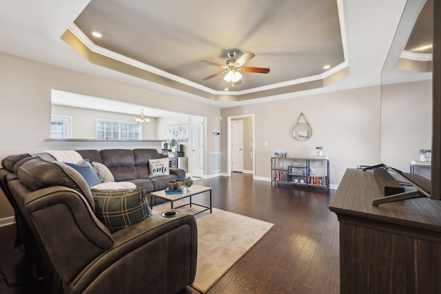 living area featuring visible vents, baseboards, dark wood-style flooring, crown molding, and a raised ceiling