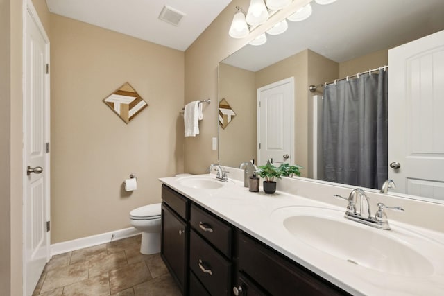 bathroom with visible vents, toilet, baseboards, and a sink