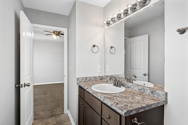 bathroom with vanity, a ceiling fan, and baseboards