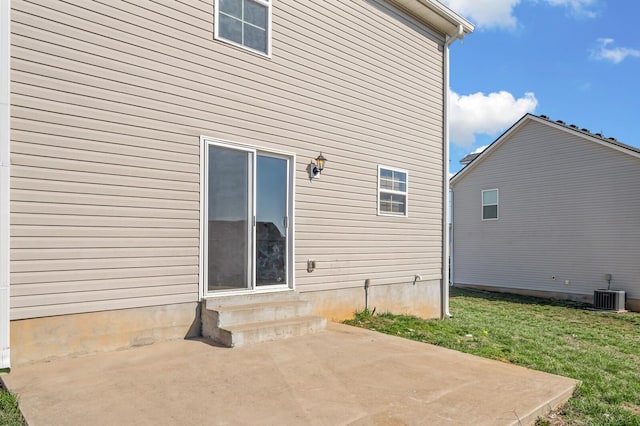 rear view of property featuring cooling unit, a patio, a lawn, and entry steps