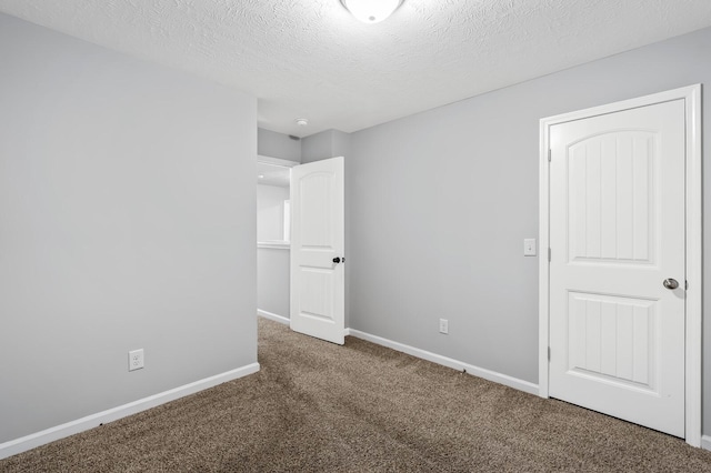 unfurnished bedroom featuring carpet, baseboards, and a textured ceiling