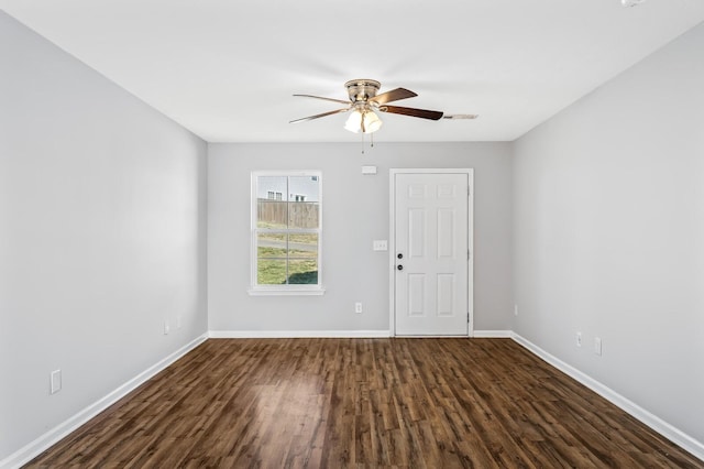 unfurnished room with visible vents, dark wood-style floors, baseboards, and ceiling fan