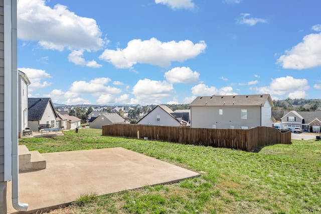 view of yard featuring fence, a patio area, and a residential view