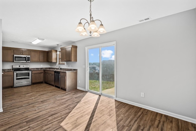 kitchen with decorative light fixtures, baseboards, dark wood-style flooring, and stainless steel appliances