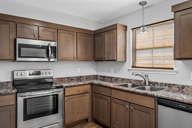 kitchen featuring dark countertops, appliances with stainless steel finishes, and a sink