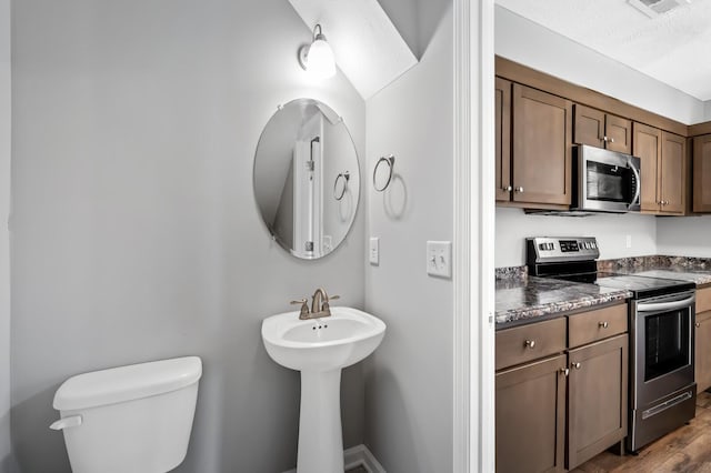 bathroom featuring toilet, wood finished floors, and visible vents