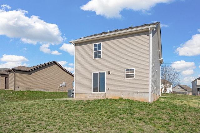 back of property with central AC unit and a lawn