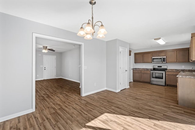 kitchen featuring open floor plan, baseboards, dark wood-style flooring, and stainless steel appliances