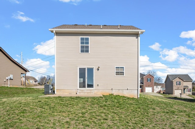 back of house featuring a lawn and central AC