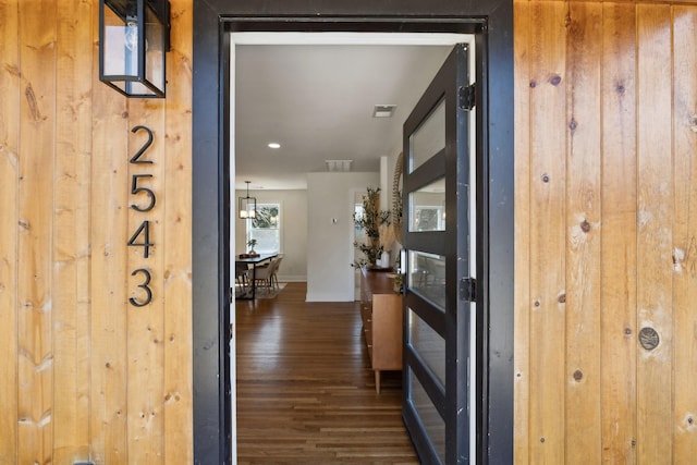 hallway featuring visible vents, baseboards, and wood finished floors