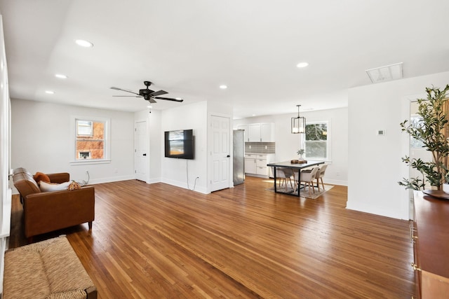 living room featuring a wealth of natural light, recessed lighting, baseboards, and wood finished floors