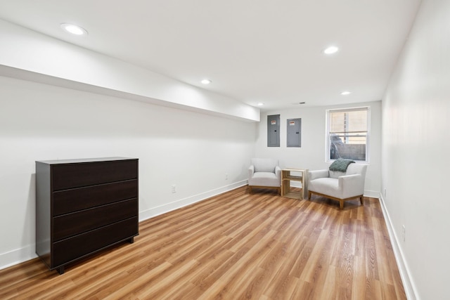 unfurnished room with electric panel, recessed lighting, light wood-style flooring, and baseboards