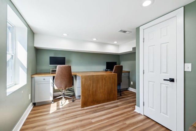 office featuring baseboards, visible vents, and light wood finished floors