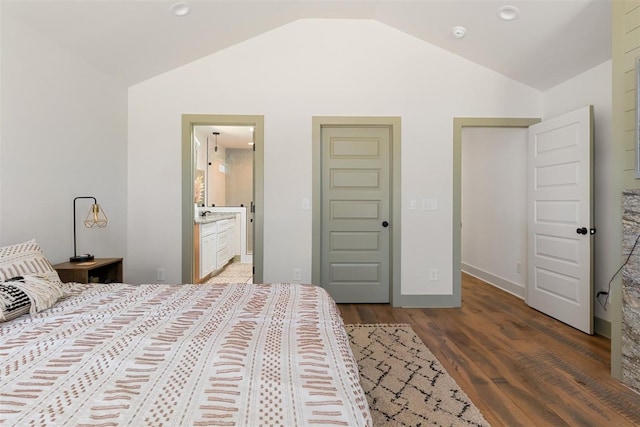 bedroom with lofted ceiling, wood finished floors, and ensuite bathroom