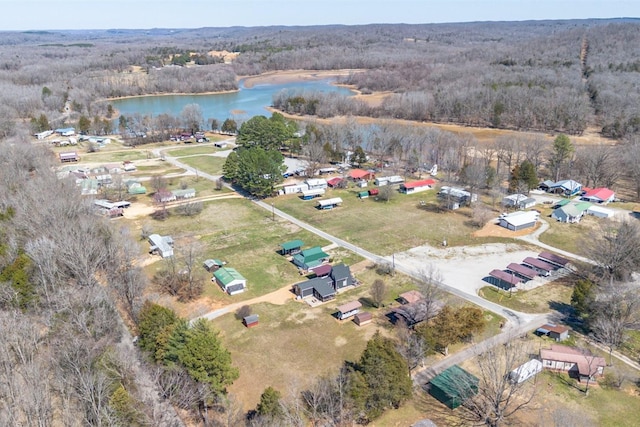 drone / aerial view with a forest view and a water view