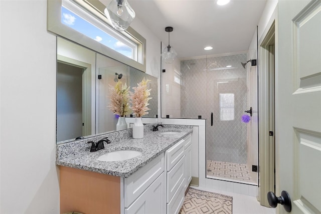 full bath with a sink, double vanity, a shower stall, and tile patterned floors