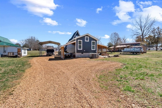 rear view of property featuring a detached carport, a lawn, cooling unit, crawl space, and driveway