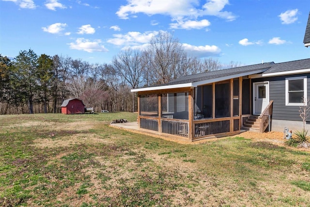 view of yard featuring an outbuilding, entry steps, a storage shed, and a sunroom