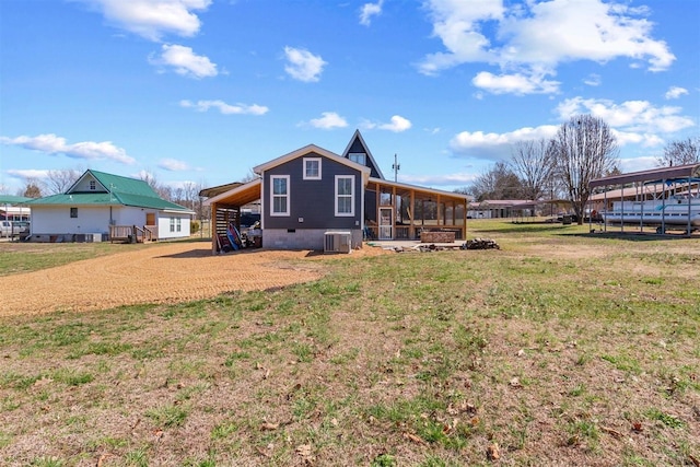 back of house featuring crawl space, an attached carport, central AC unit, and a lawn