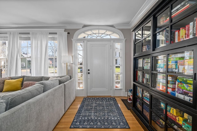 entrance foyer featuring crown molding and light wood-style floors