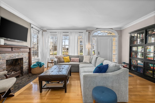 living room featuring light wood finished floors, a fireplace with flush hearth, and ornamental molding