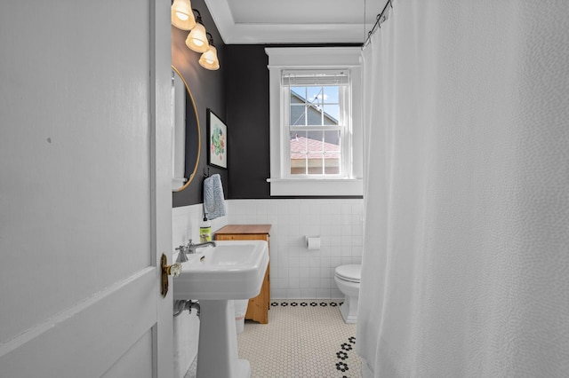 bathroom featuring a wainscoted wall, tile patterned flooring, curtained shower, tile walls, and toilet