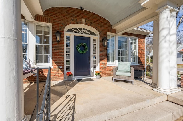 property entrance with brick siding and covered porch